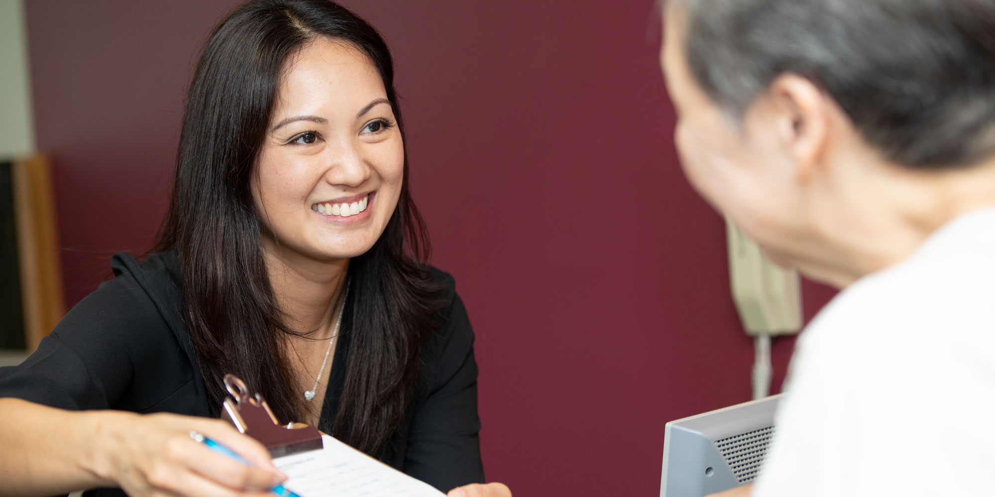 dental front desk assistant giving form to patient Annandale, VA